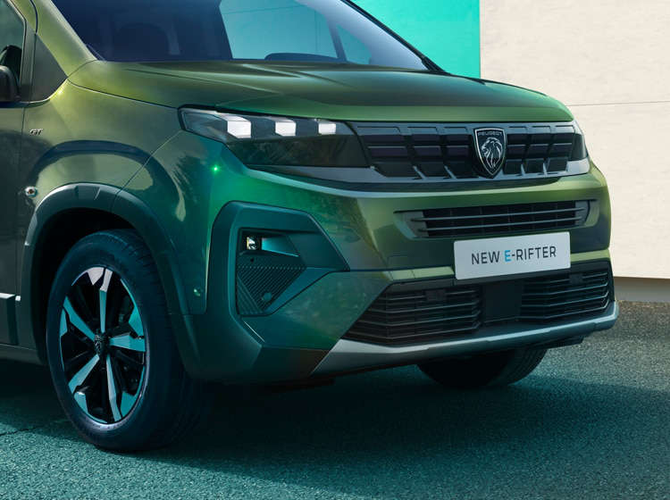 Чоловік стоїть перед Peugeot Rifter, жінка біля водійських дверей
